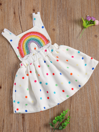 Baby white dress has a colorful polka dot print and rainbow applique pullover style ties at the back