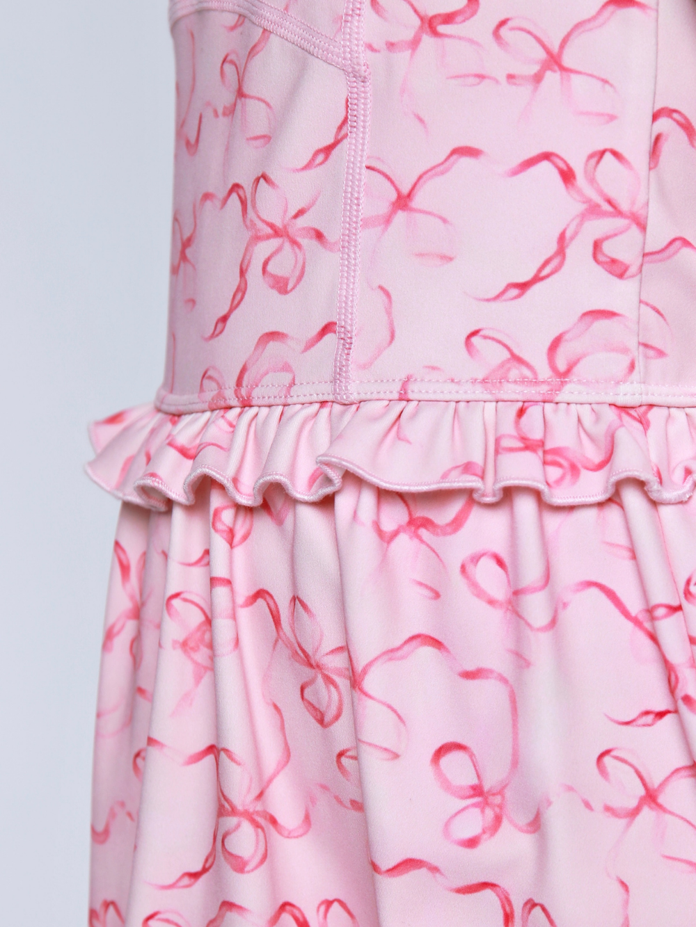 Close up of pink fabric with ribbon bow print design