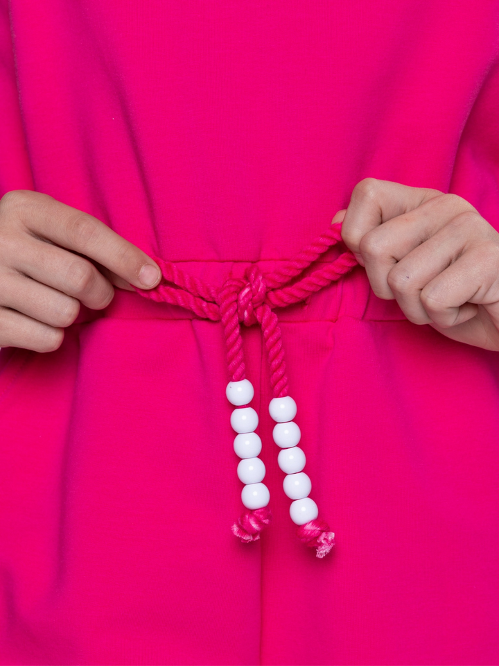 Close up of pink romper drawstring waist with bead detail