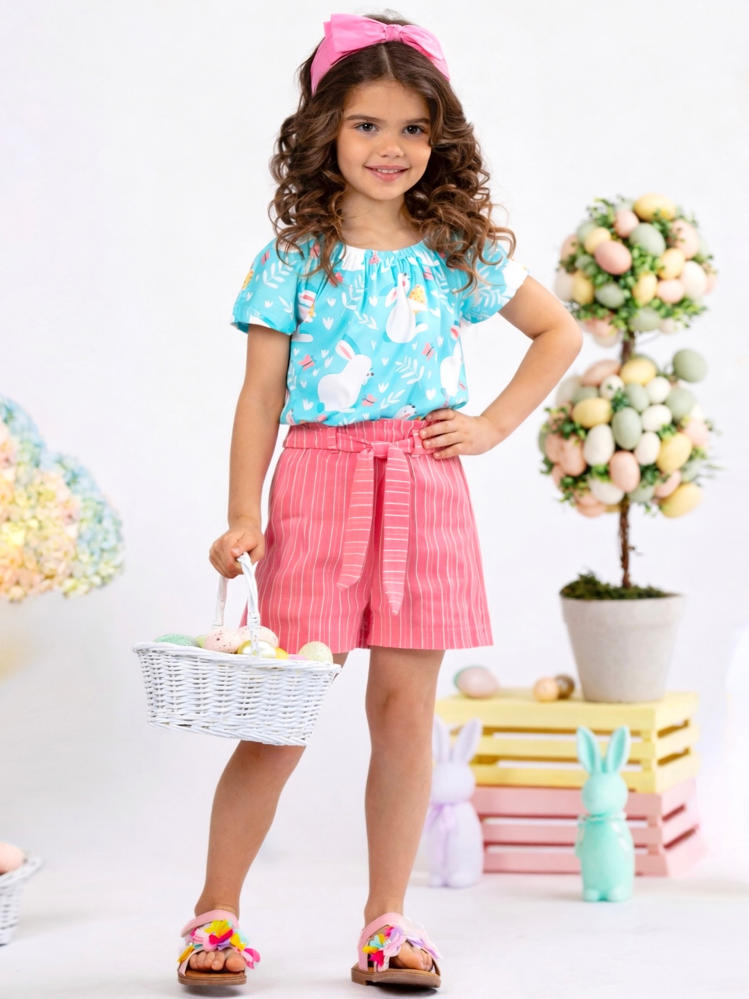 Girl wearing a bunny printed Easter short set with mint top and pink striped shorts