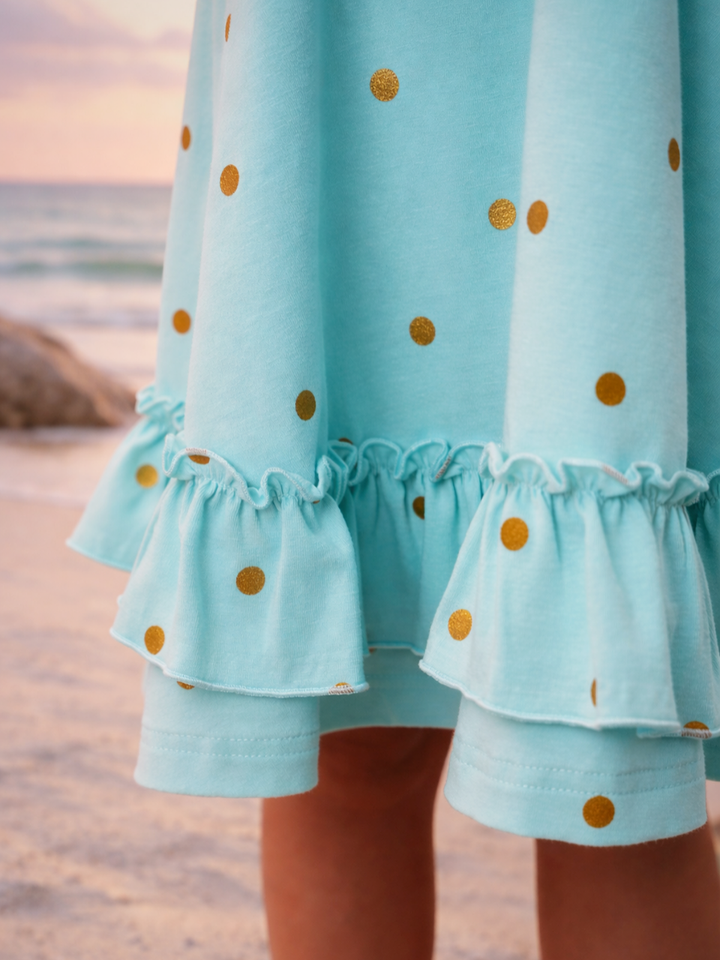 Girl wearing summer vacation dress with polka dots and ruffle neckline