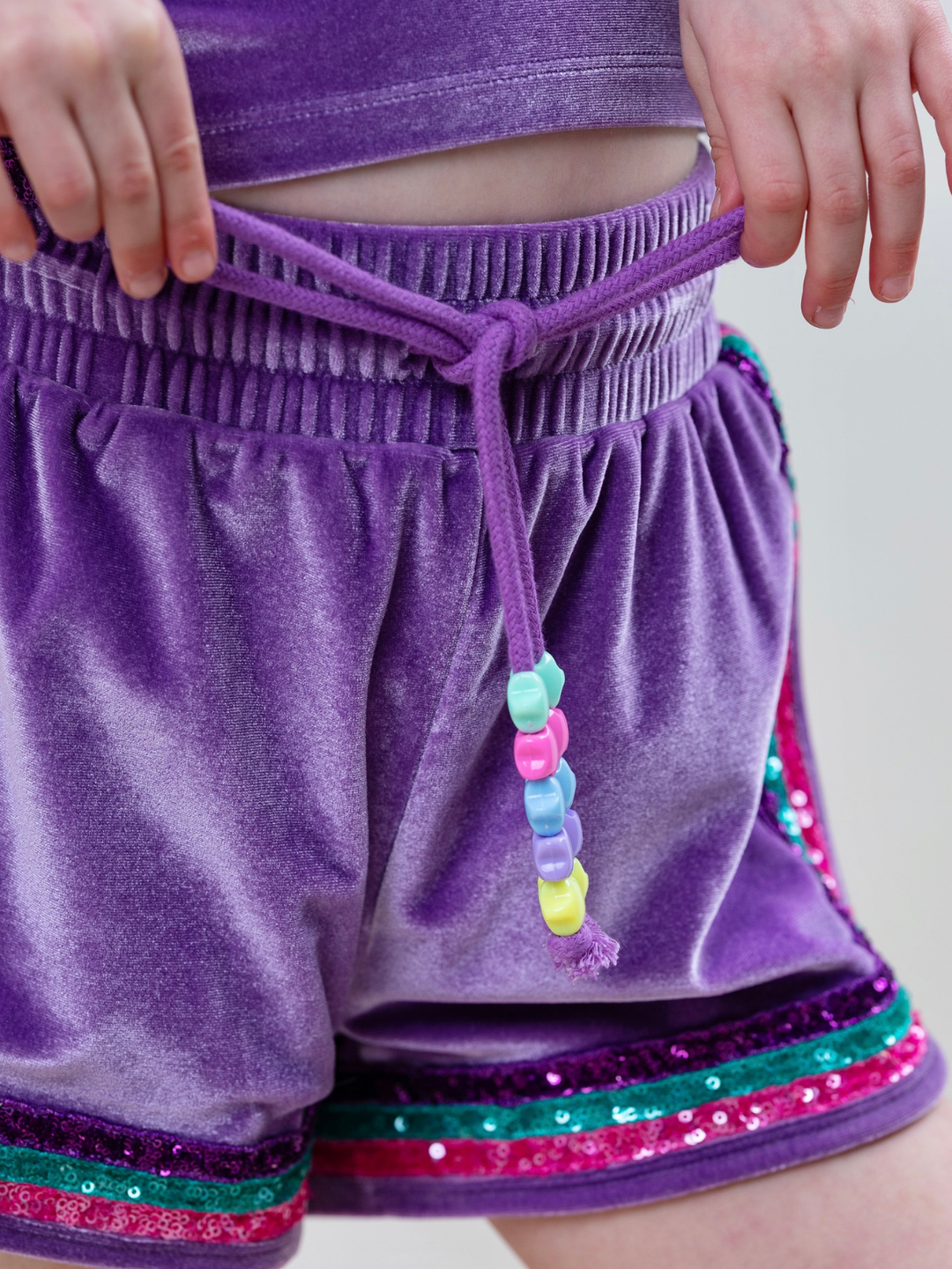Girl wearing sparkly mermaid outfit with colorful trim and soft velour