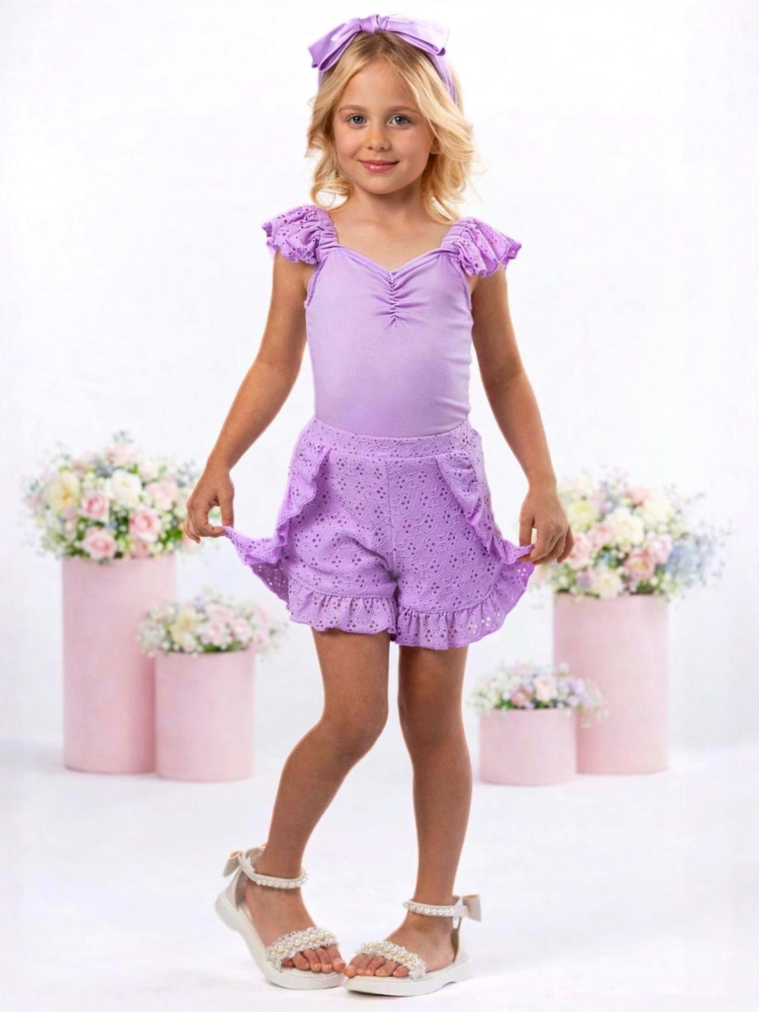 Girl wearing purple eyelet shorts set with ruffle trim for everyday wear