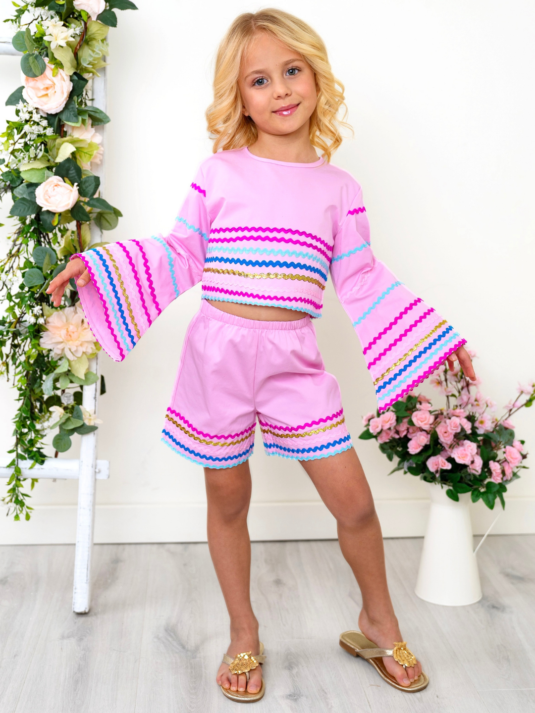 Girl wearing pink summer outfit with ric rac trim crop top and shorts