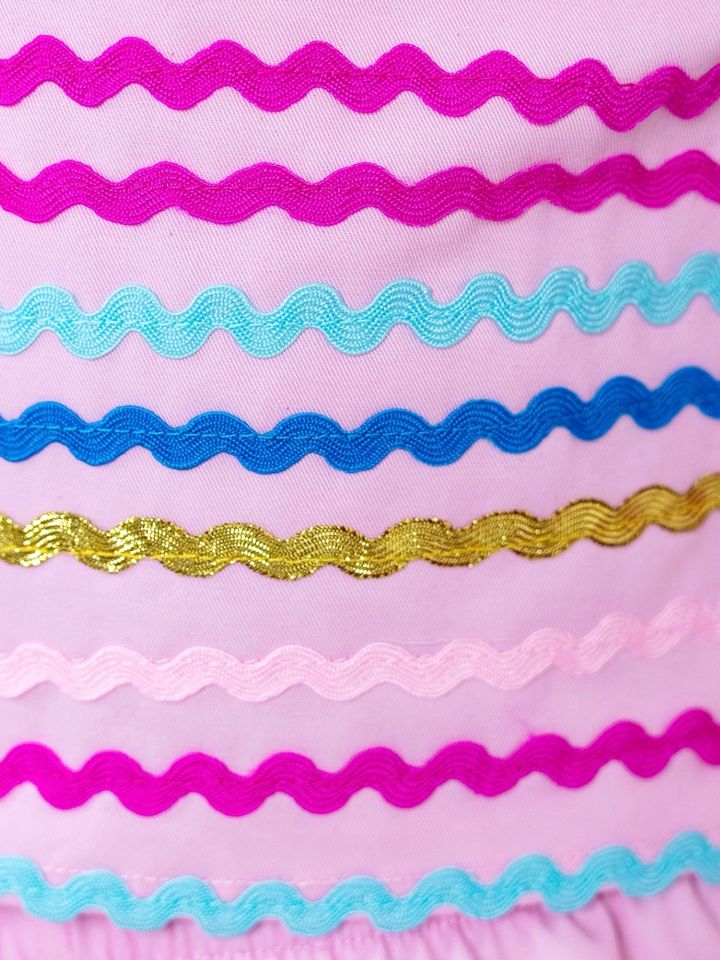 Close up of colorful ric rac trim on girls pink sleeve
