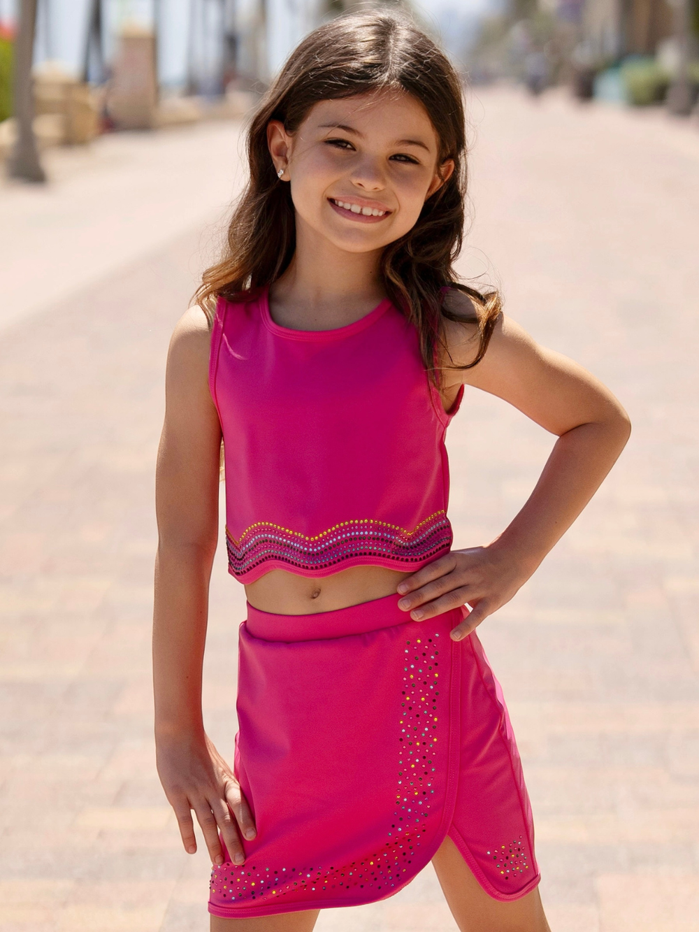 girl wearing pink crop top and skort set with sparkle trim