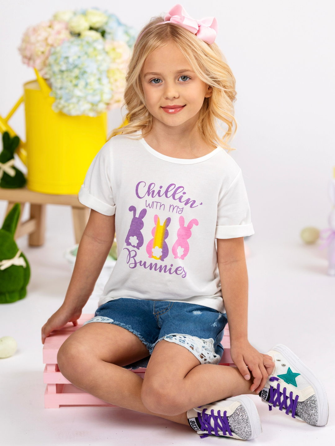 Girl wearing a white Easter graphic top with “Chillin’ with My Bunnies” bunny design