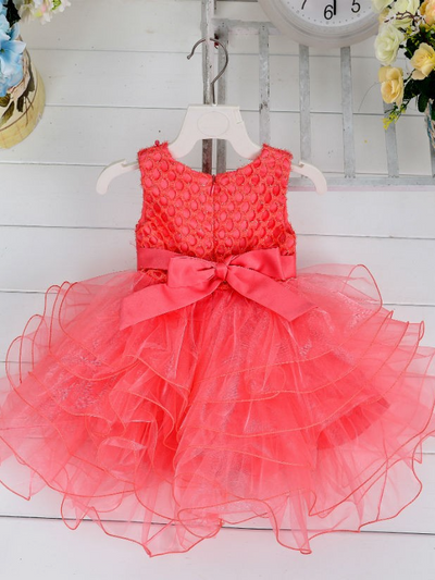 Baby princess dress has a satin bodice with pearl details, a bow belt at the waist, and a layered tulle skirt -coral
