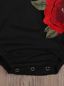 Baby little onesie has big red flower appliques and ties at the back for easy slip-on black