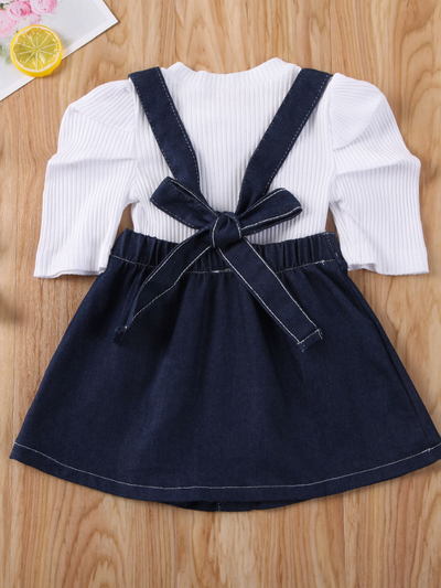 Girls set features a white top with a red/blue bow and a denim suspender skirt