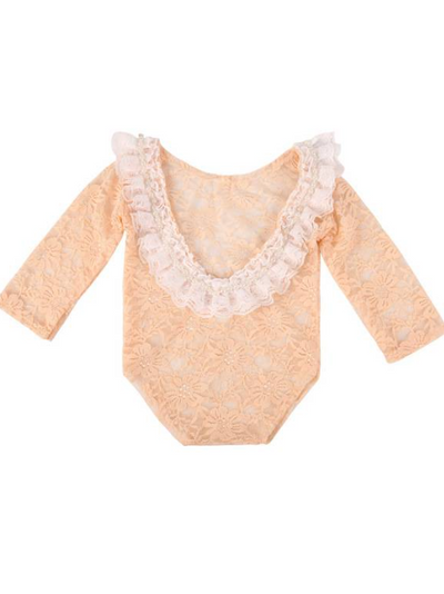 Baby lace onesie has an open back with white lace ruffles  peach