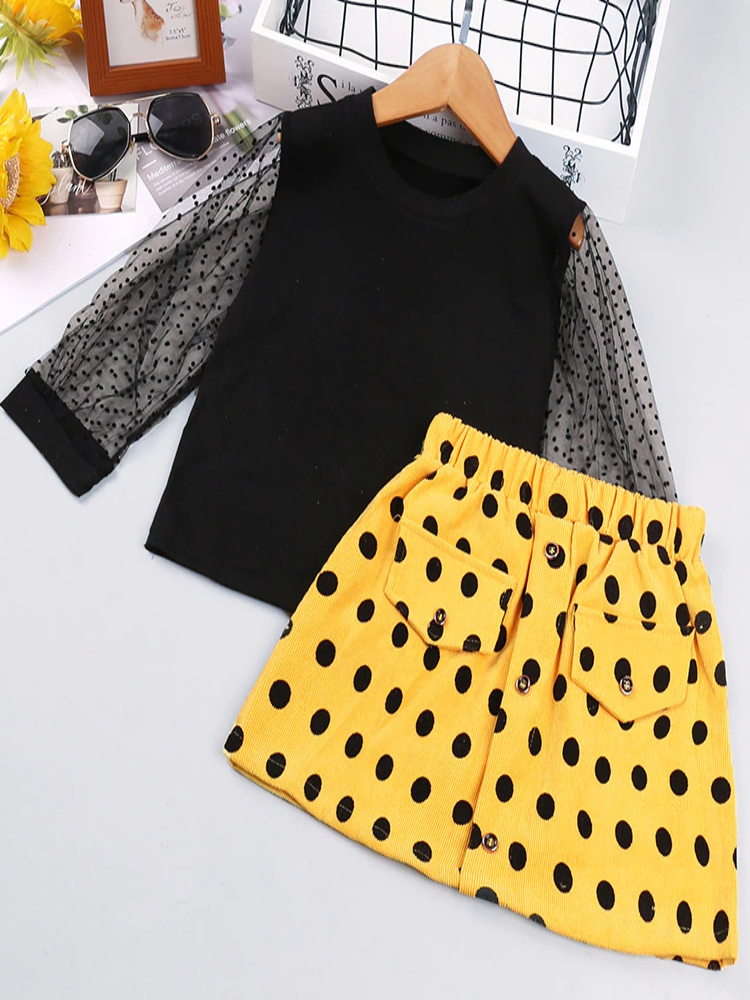 Girls set features a top with swiss tulle sleeves and a yellow and black polka dot skirt