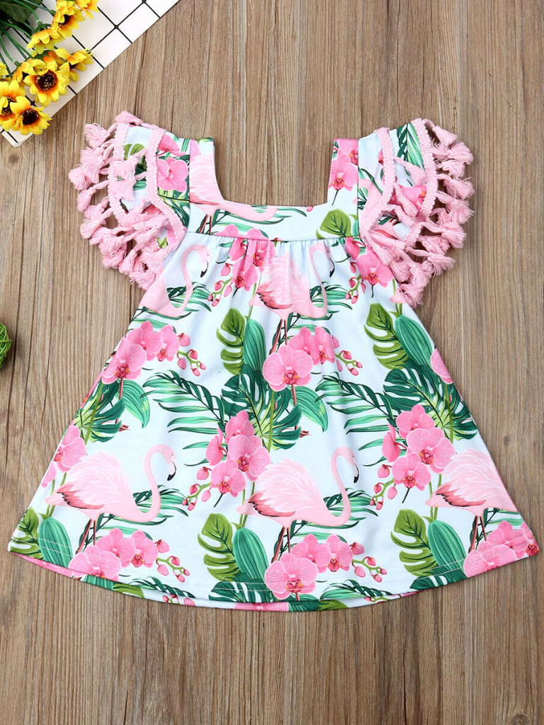 Baby apron style dress has a flamingo and tropical leaf print, a cute tasseled hem at the ruffled shoulders add a little extra-extra 