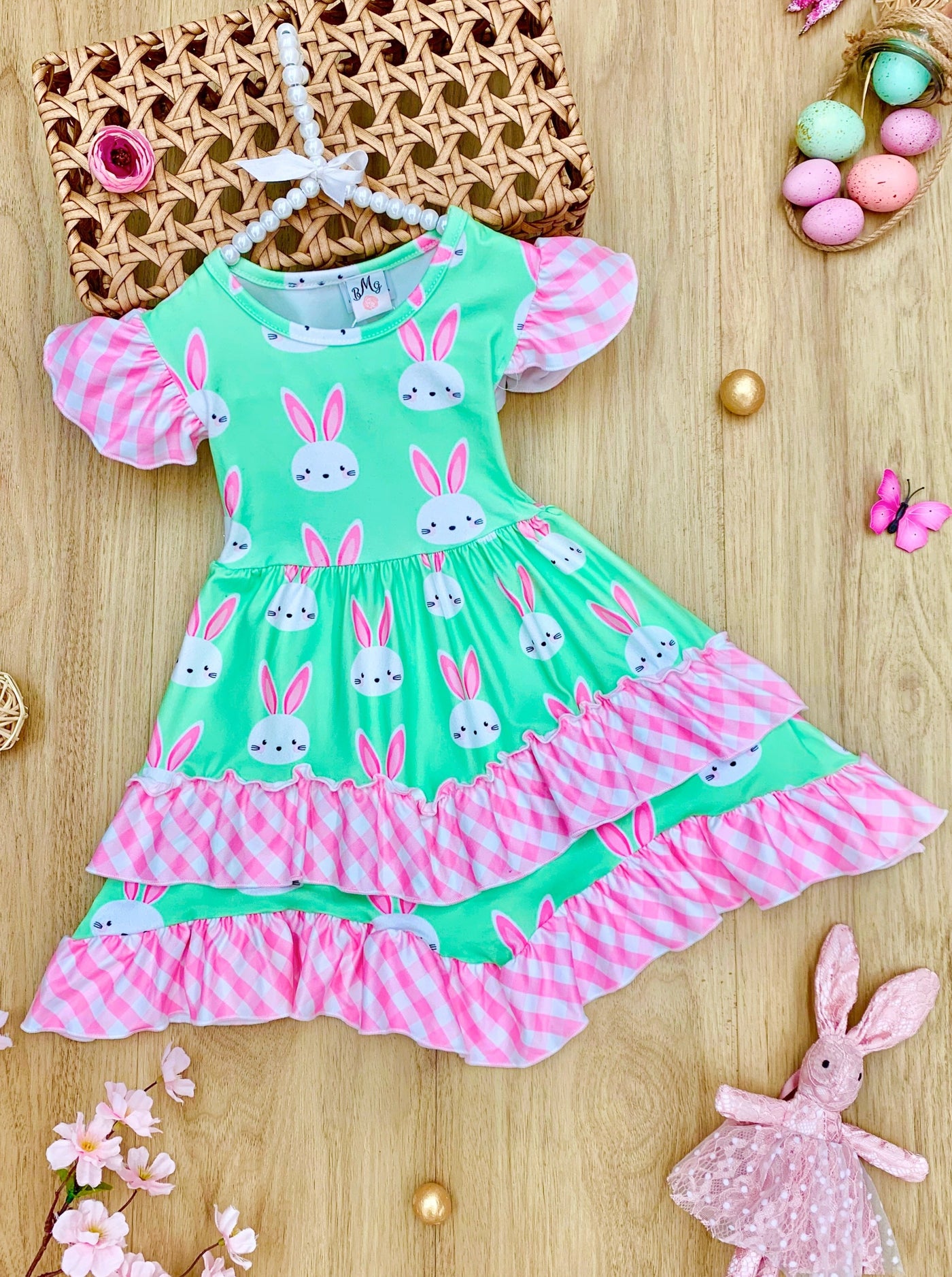 Girls Easter dress features a bunny print two-tiered design with Gingham flutter sleeves and hem 