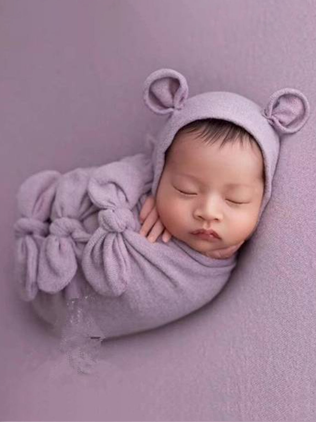 Baby features a shawl - wrap that has knots in the front with a cap with ears and a little pillow - taupe