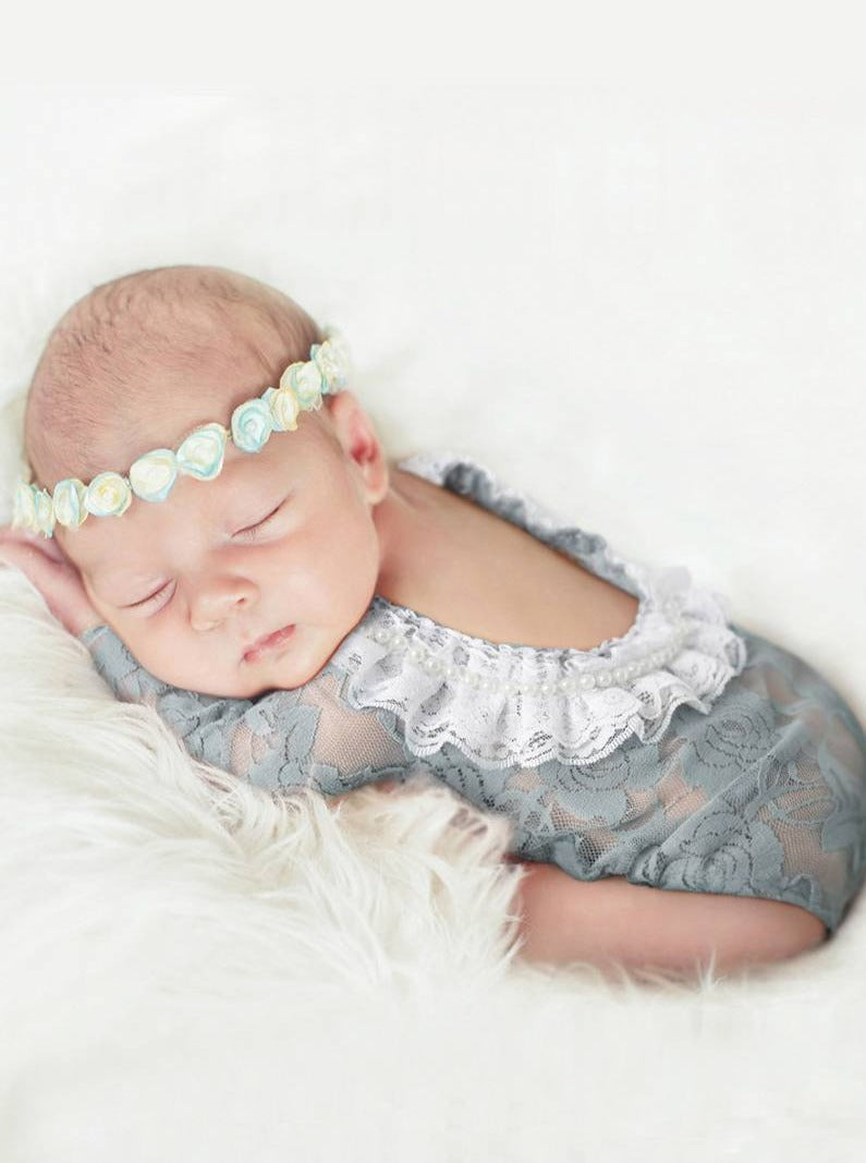 Baby  lace onesie has an open back with white lace ruffles grey