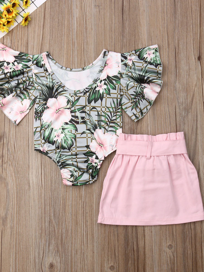 Baby set has a ruffled onesie with tropical print and pink skirt with front buttons and sash