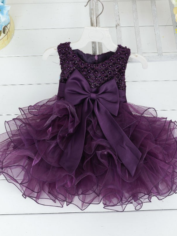 Baby princess dress has a satin bodice with pearl details, a bow belt at the waist, and a layered tulle skirt -purple