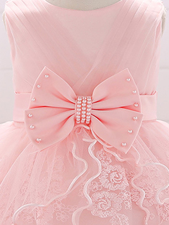Baby dress has a tulle overlay with a multi-layer skirt, bow detail at the waist-