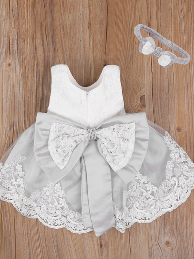 Girls Spring dress has a short-sleeved lace bodice and a skirt with lace hem and a big bow on the back, comes with a matching headband