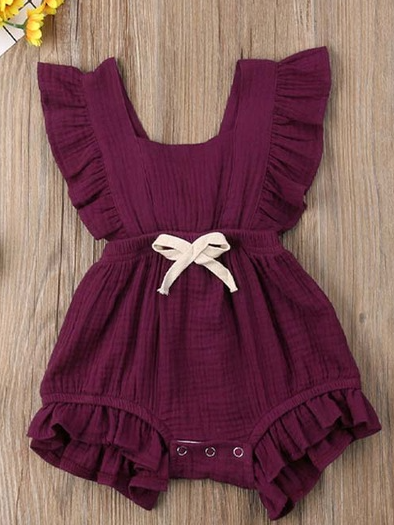 Baby bohemian Overall style romper onesie that ties in the back and has a drawstring at the waist. Little ruffled adorn the shoulder and short hem burgundy