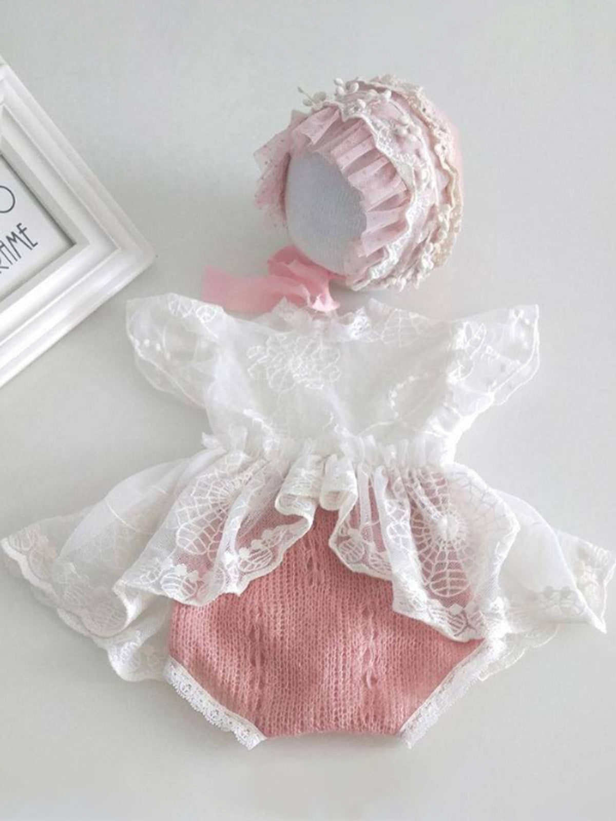 Baby set features a skirted onesie with a lace bodice and a matching cap pink