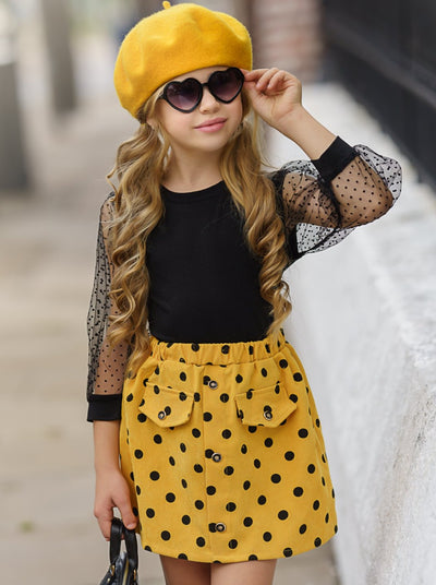 Girls set features a top with swiss tulle sleeves and a yellow and black polka dot skirt