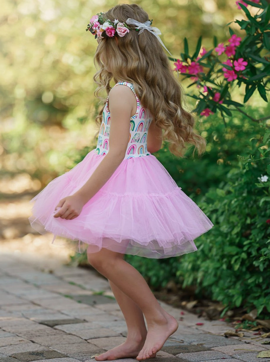 Girls dress has a white bodice with rainbow prints and a full pink tutu skirt
