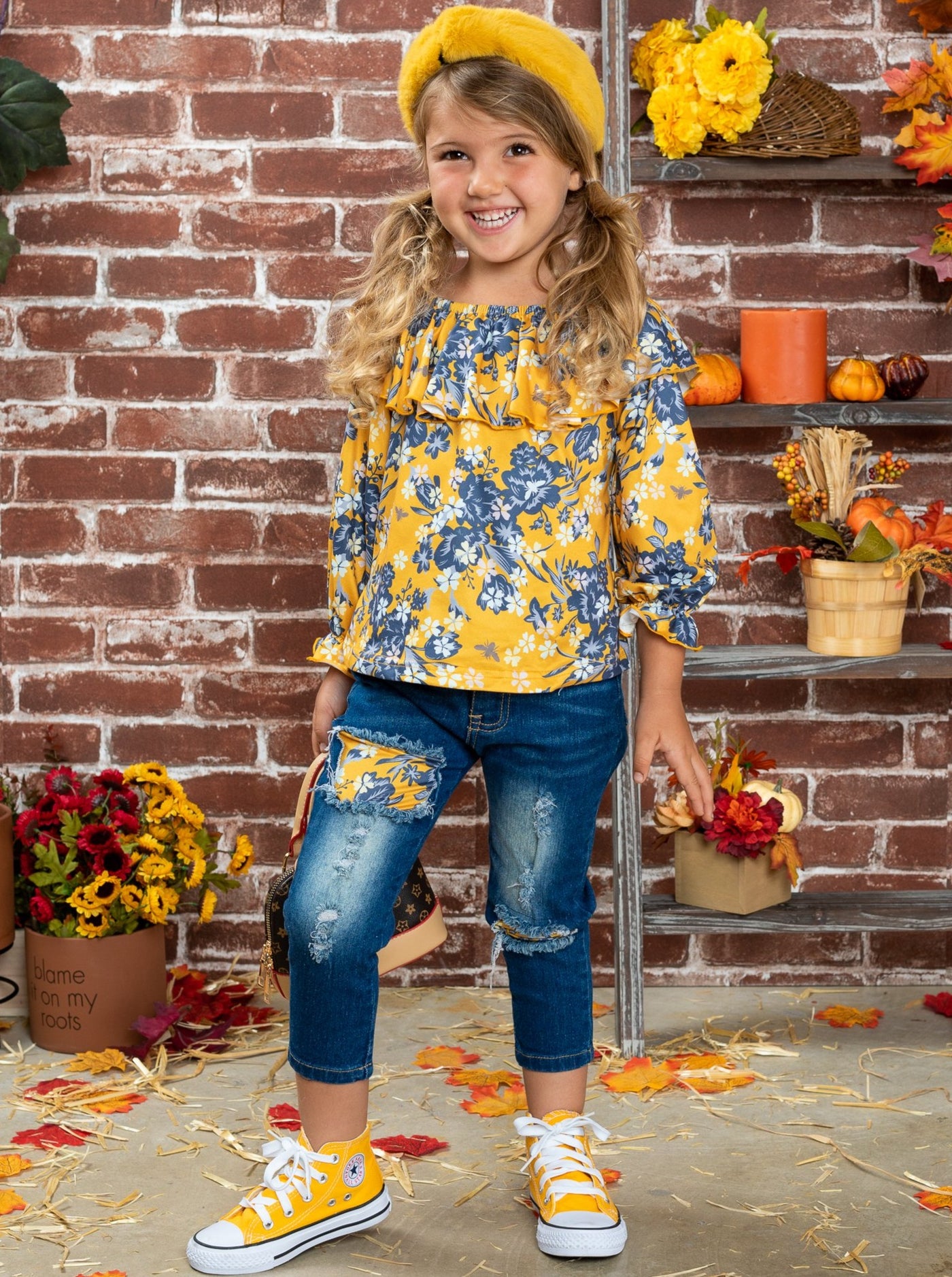 Girls set features a double ruffle neckline bib, floral top, and patched jeans.
