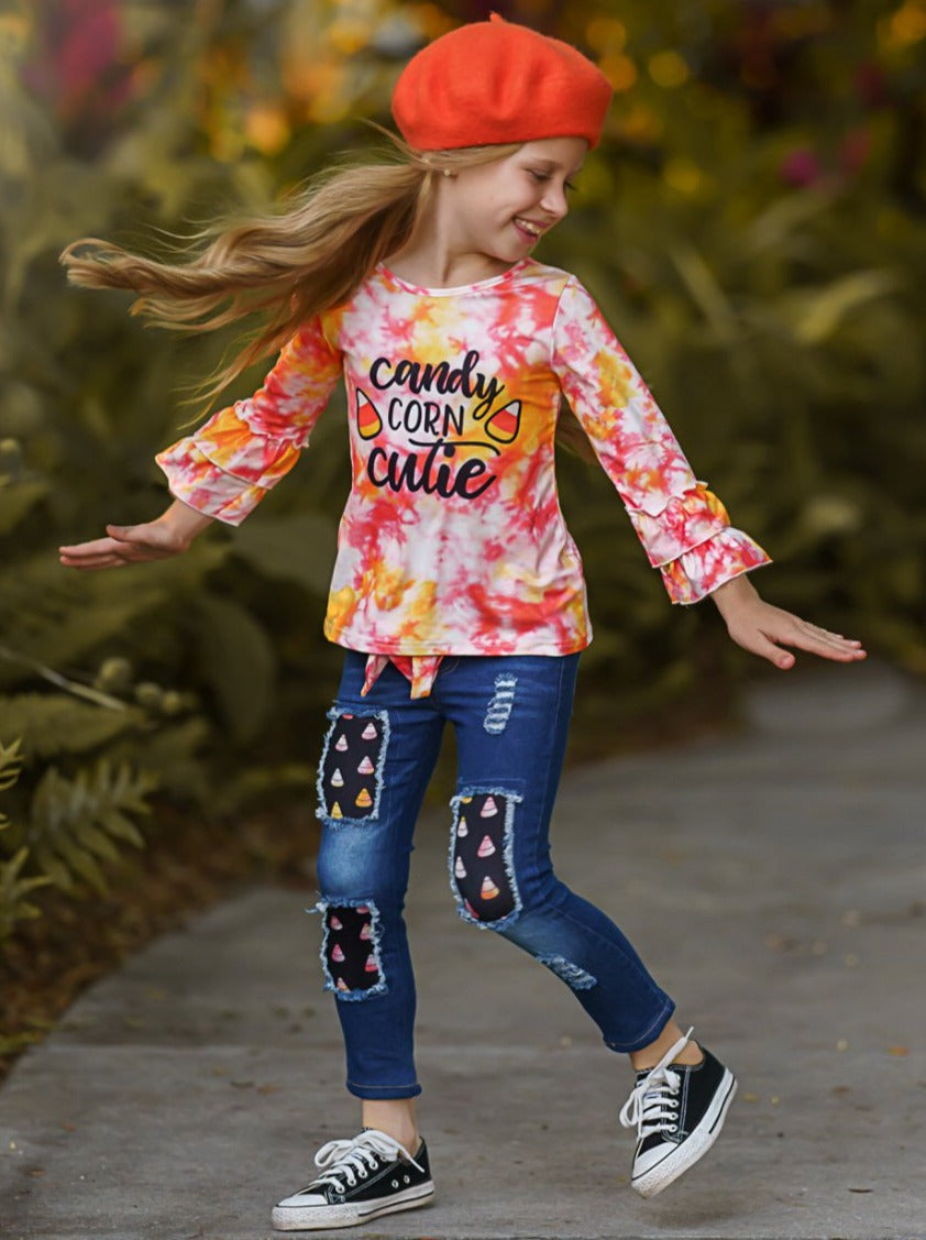 Little girls long-sleeve tie-dye top with double ruffle cuffs, "Candy Corn Cutie" graphic print, fabric-patched jeans, and a matching tie-dye sash belt - Mia Belle Girls