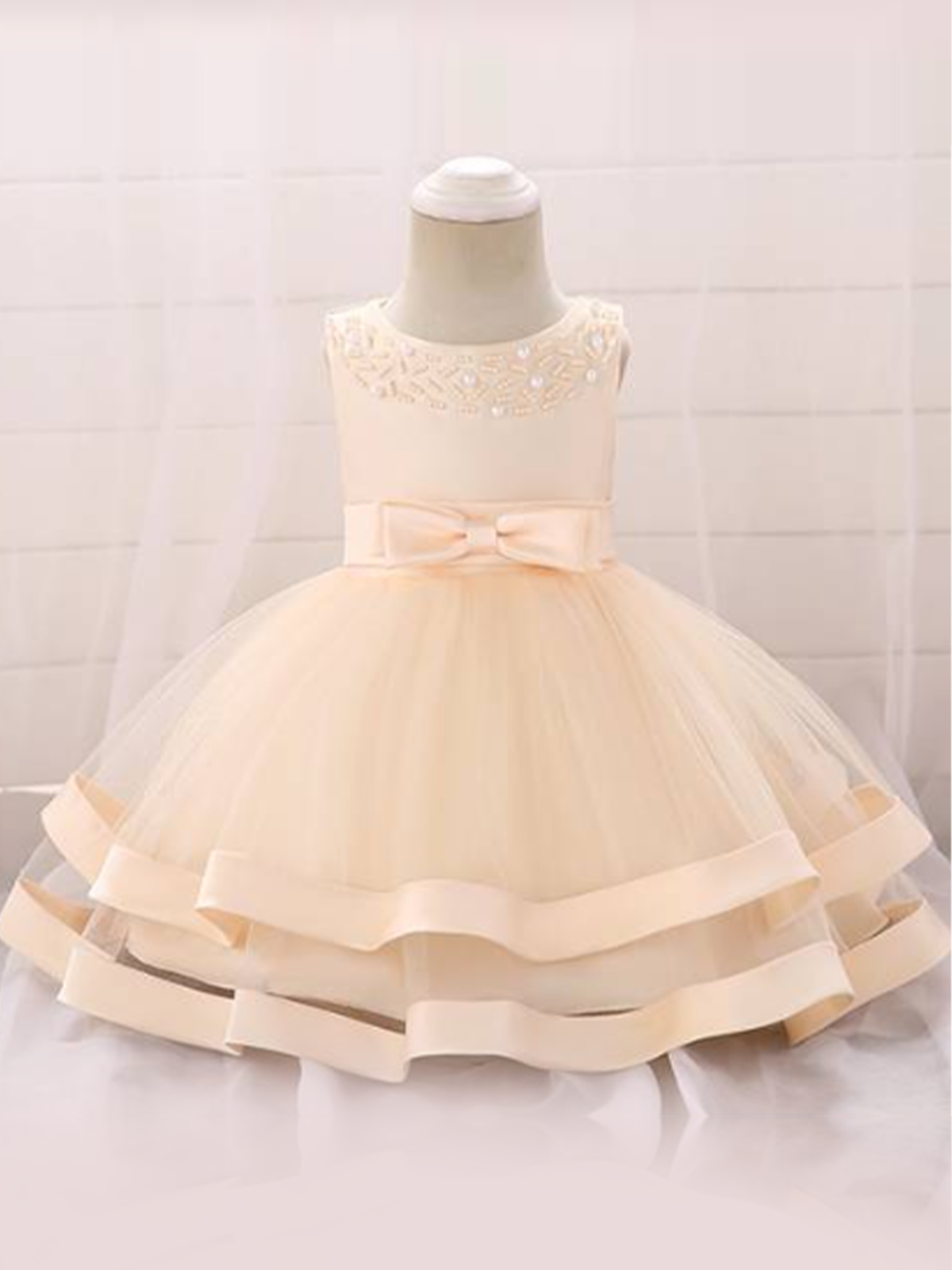 Baby dress features beautiful beads on the bodice, voile with satin hem-creme