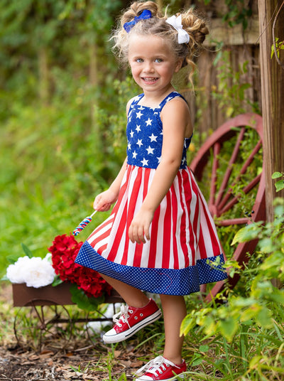 girls dress features a blue bodice with white stars, a red/white striped skirt, and a starred hem