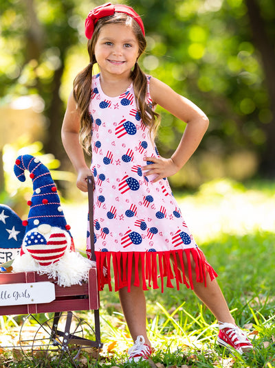 Girls pink dress features an Americana print with fun fringes at the hem