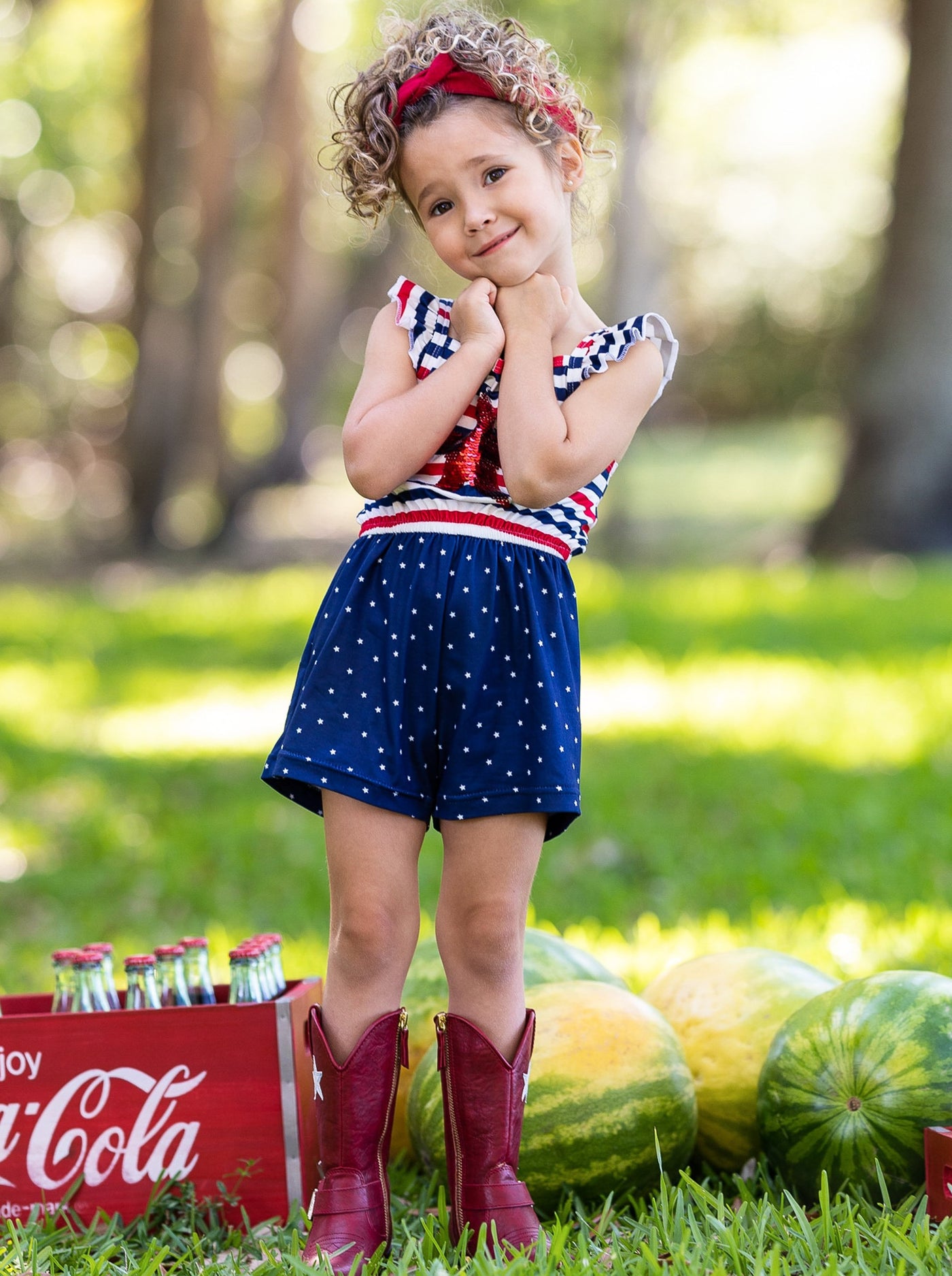 Girls romper features a white, blue, and red striped bodice with red sequin star and flutter sleeves, and blue shorts with white polka dots 2T-10Y for toddlers and girls