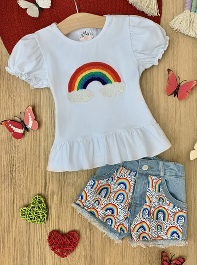 Girls set features a white top with rainbow graphic print and denim shorts with rainbow patches
