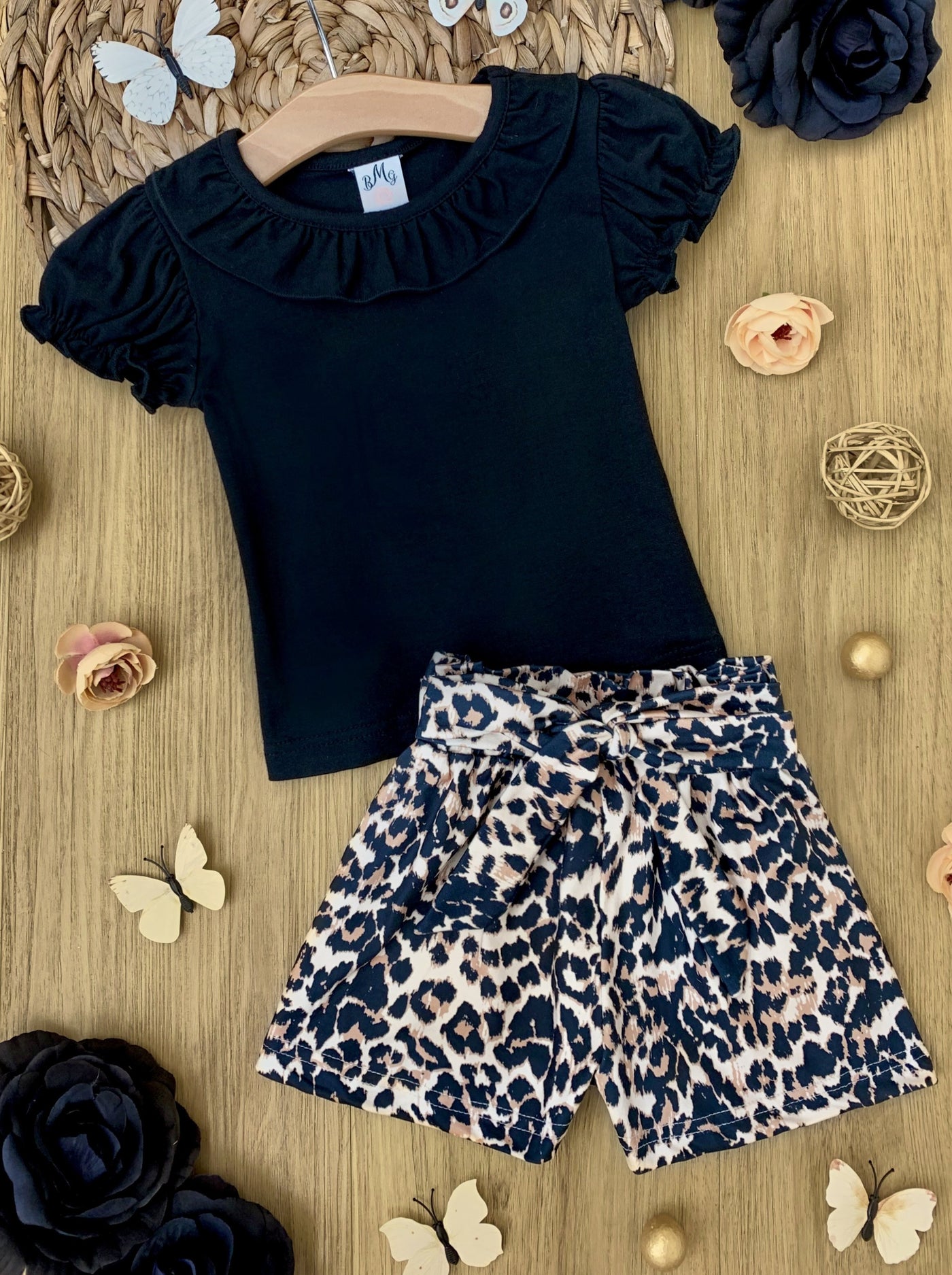 girls set features a black top with a bib and ruffled short sleeves and leopard printed shorts with a sash