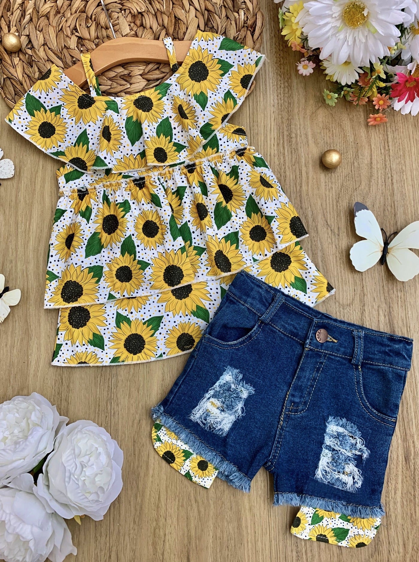 girls set features a white top multi-layer top with off-shoulder sleeves and sunflower print and denim shorts with sunflower patches