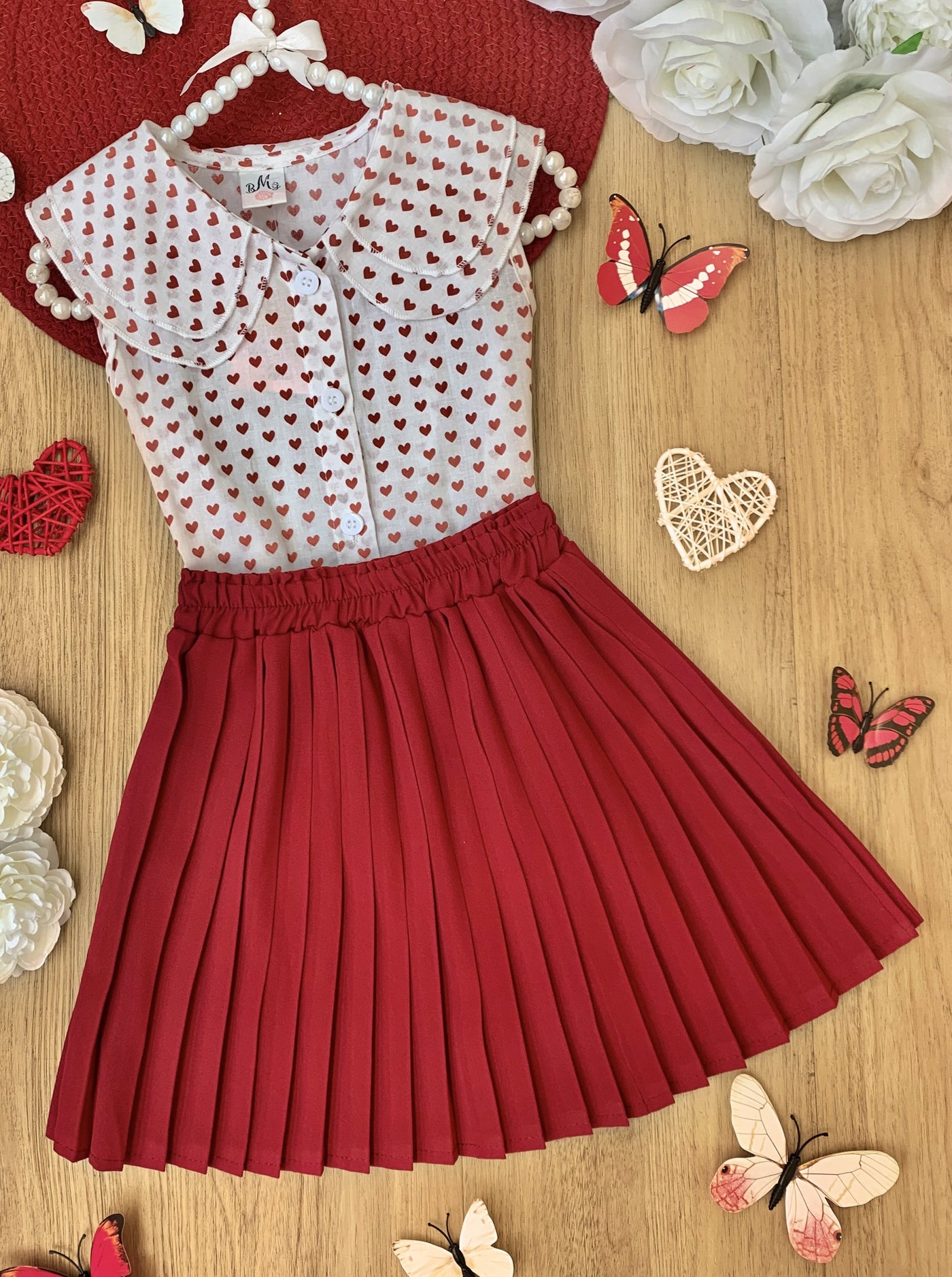 Girls  set features a top with a cute collar and heart prints and red pleated skirt