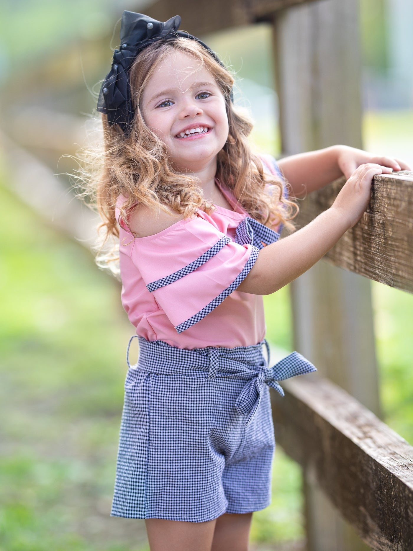 girls pink top with grey bow and matching grey shorts with sash