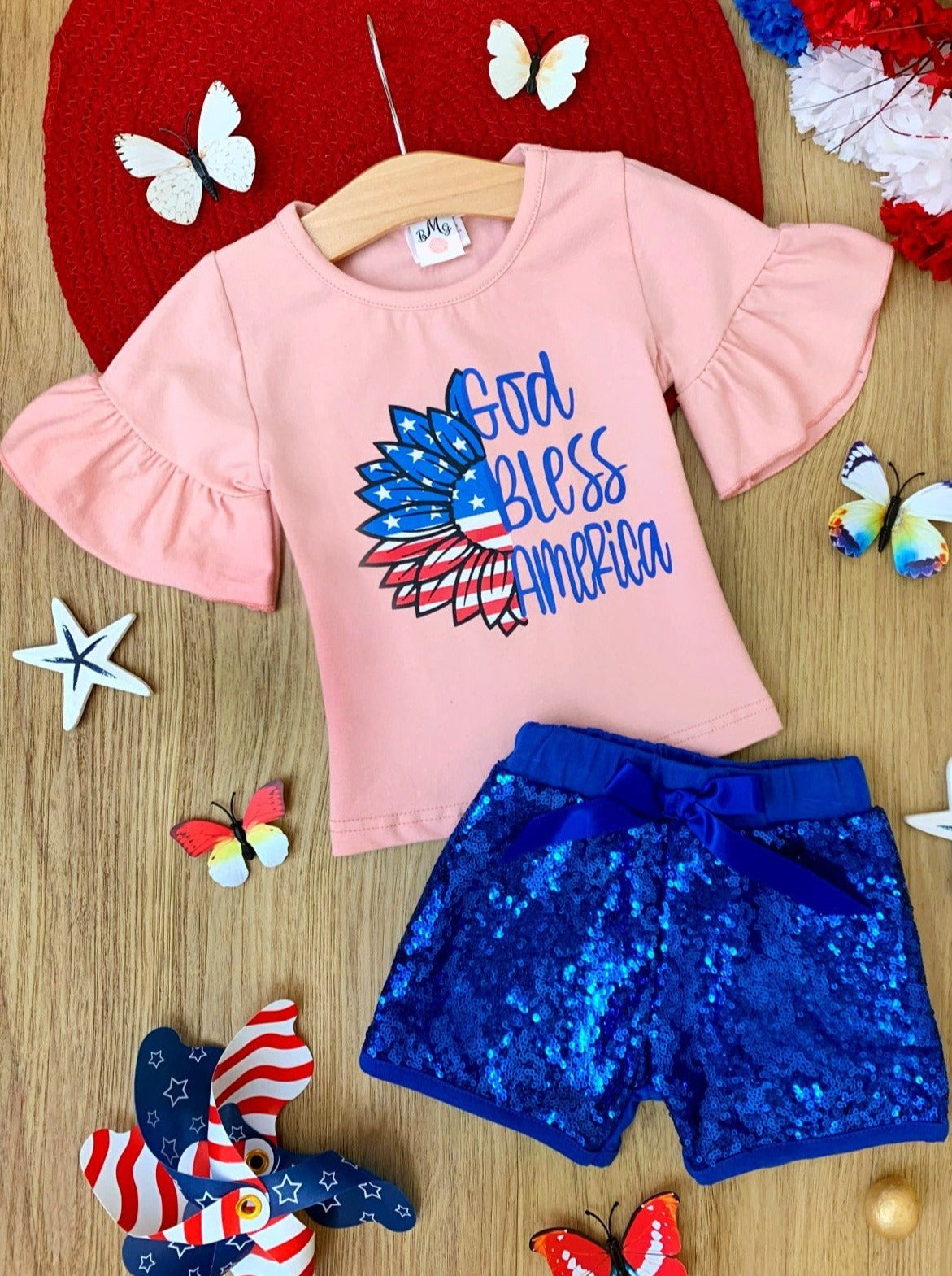 Girls Set features a white top with "God Bless America" print and sequin shorts with a sash