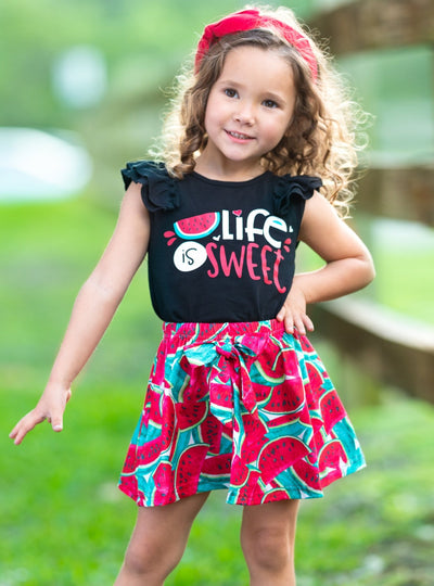 Girl with red headband wearing black top with "Life is Sweet" print and skirt with watermelon print