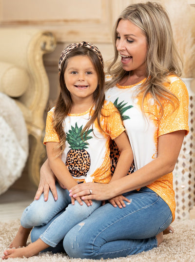 Mother-daughter top features tie-dye sleeves, back, and hem with a leopard print pineapple graphic design - 12MON-8Y for toddlers and girls and S to XL for Moms