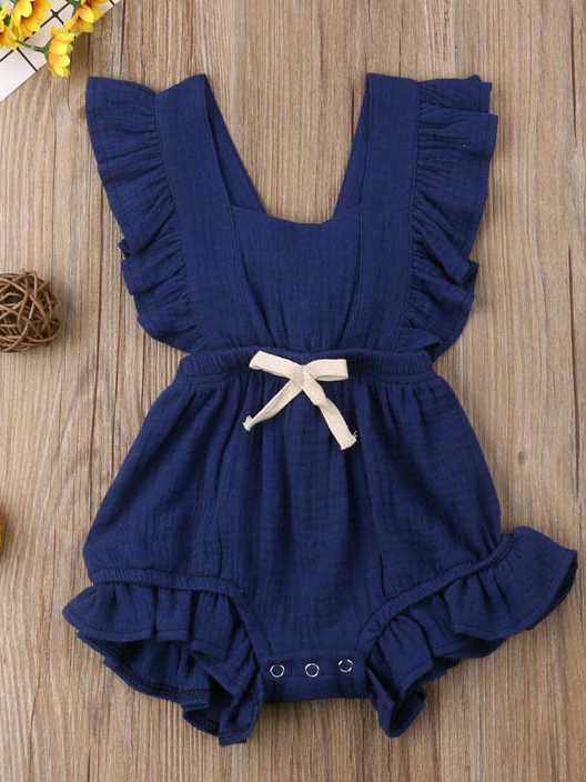 Baby bohemian Overall style romper onesie that ties in the back and has a drawstring at the waist. Little ruffled adorn the shoulder and short hem navy