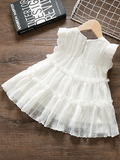 Baby swiss tulle dress has delicate ruffles and a little bow at the front