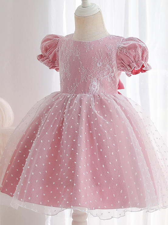 Baby dress has capped sleeves and embroidered tulle overlay bodice and swiss tulle overlay skirt, big bow accent at the back