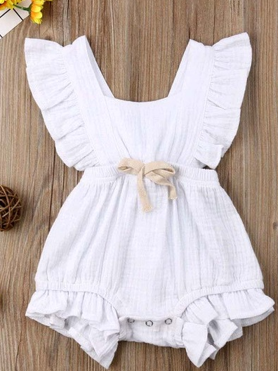 Baby bohemian Overall style romper onesie that ties in the back and has a drawstring at the waist. Little ruffled adorn the shoulder and short hem white