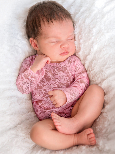 Baby lace onesie has an open back with white lace ruffles  pink
