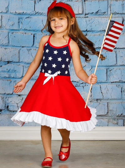 Girls 4th of July dress features a navy racerback bodice with white stars, a hi-lo red skirt with a ruffled white hem