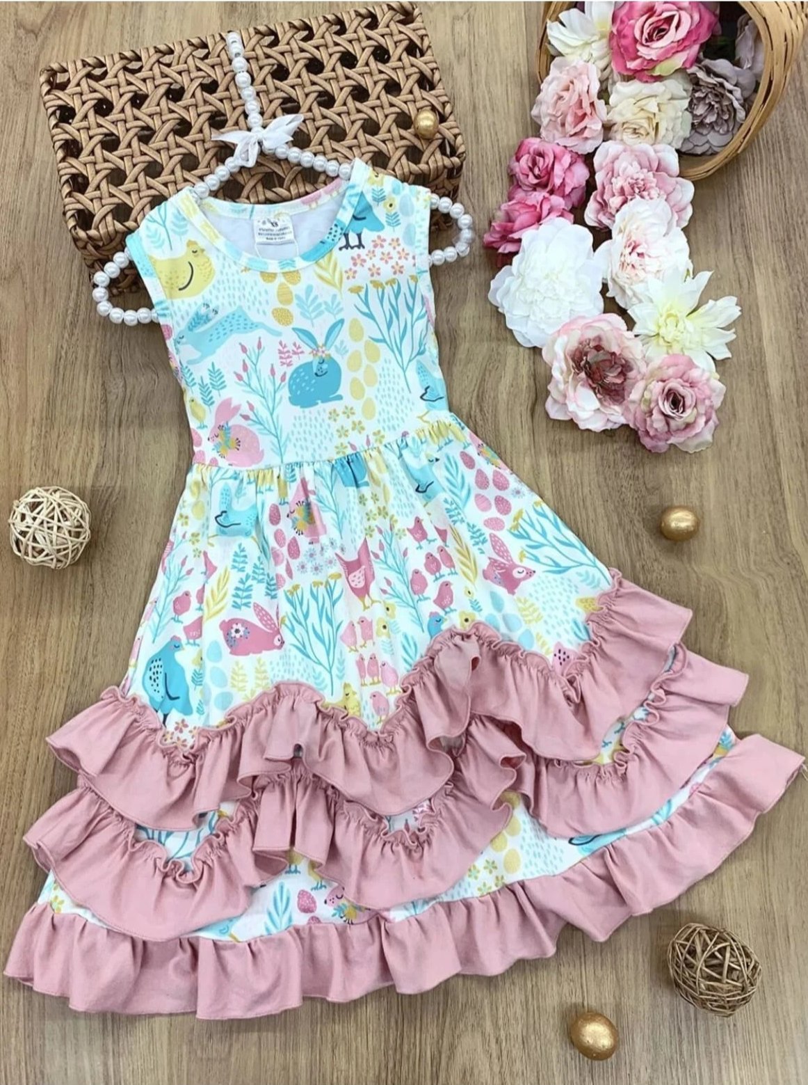 Casual dress features a tiered ruffled hem and a print that features animals (rabbits and chickens), florals, and leaves 