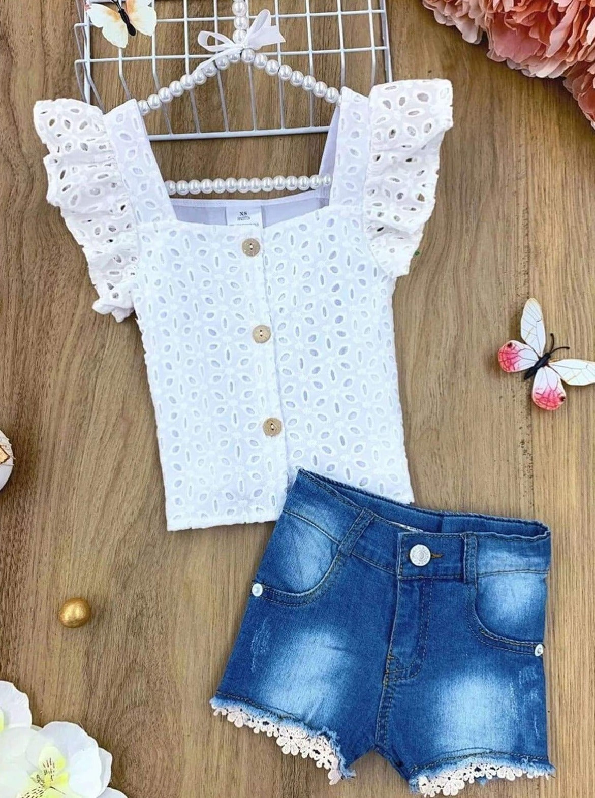 features a lace flutter sleeve button-down top  and denim shorts with a crochet flower hem